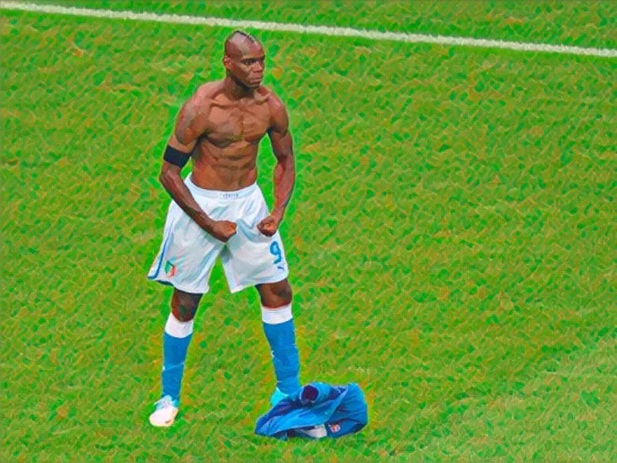 L'attaccante italiano Mario Balotelli esulta a torso nudo, flettendo i muscoli con il volto serio e senza espressione dopo il secondo gol alla Germania a Euro 2012