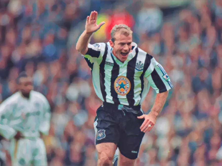 Alan Shearer esulta correndo a braccio destro alzato con la maglia bianconera del Newcastle United