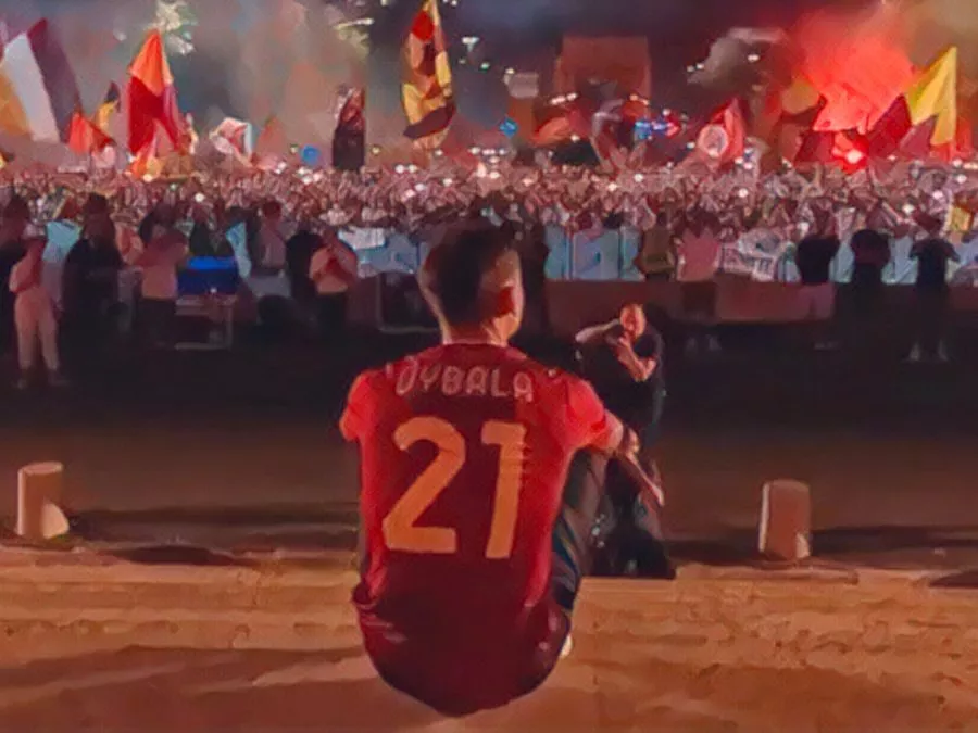 Paulo Dybala seduto sui gradini del Palazzo della Civiltà Italiana all'EUR mentre osserva commosso i 10.000 tifosi della Roma festeggiare con fumogeni e bandiere il 26 luglio 2022