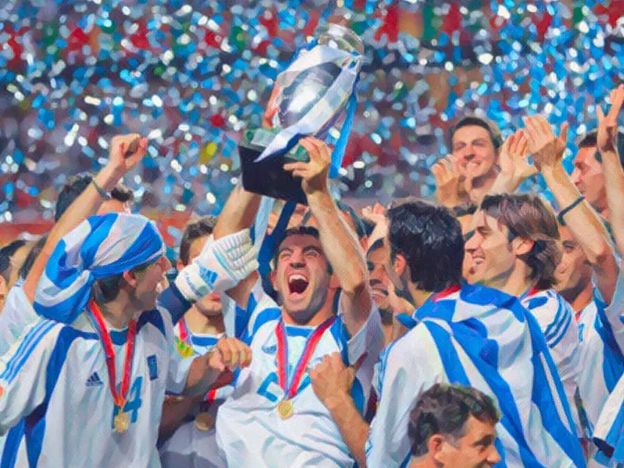 I giocatori della Nazionale greca sollevano la coppa di Euro 2004 tra i coriandoli argentati sul podio dello Stadio Da Luz di Lisbona il 4 luglio 2004