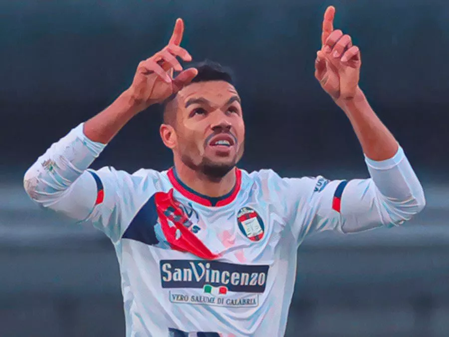 Junior Messias esulta sorridente indicando il cielo dopo un gol segnato con la maglia del Crotone