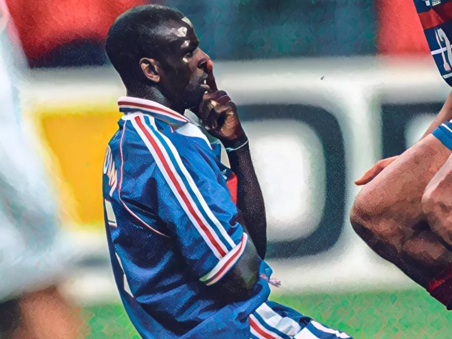 Lilian Thuram in ginocchio con la mano sulla bocca, con l'espressione incredula e stupita, mentre festeggia la sua storica doppietta contro la Croazia nella semifinale dei Mondiali 1998