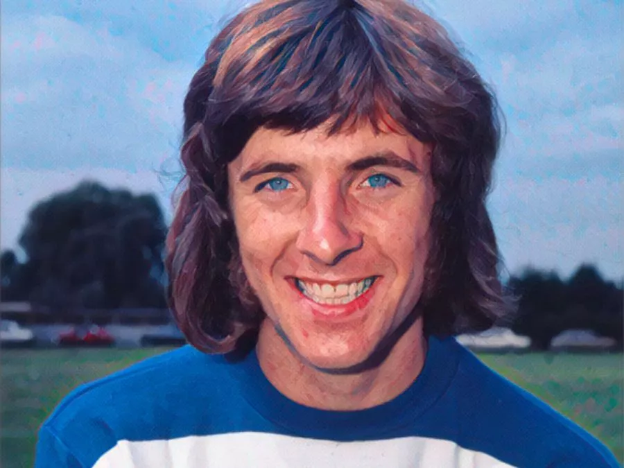 Stan Bowles con la maglia a strisce orizzontali bianche e blu del Queens Park Rangers e i capelli lunghi tipici degli anni '70