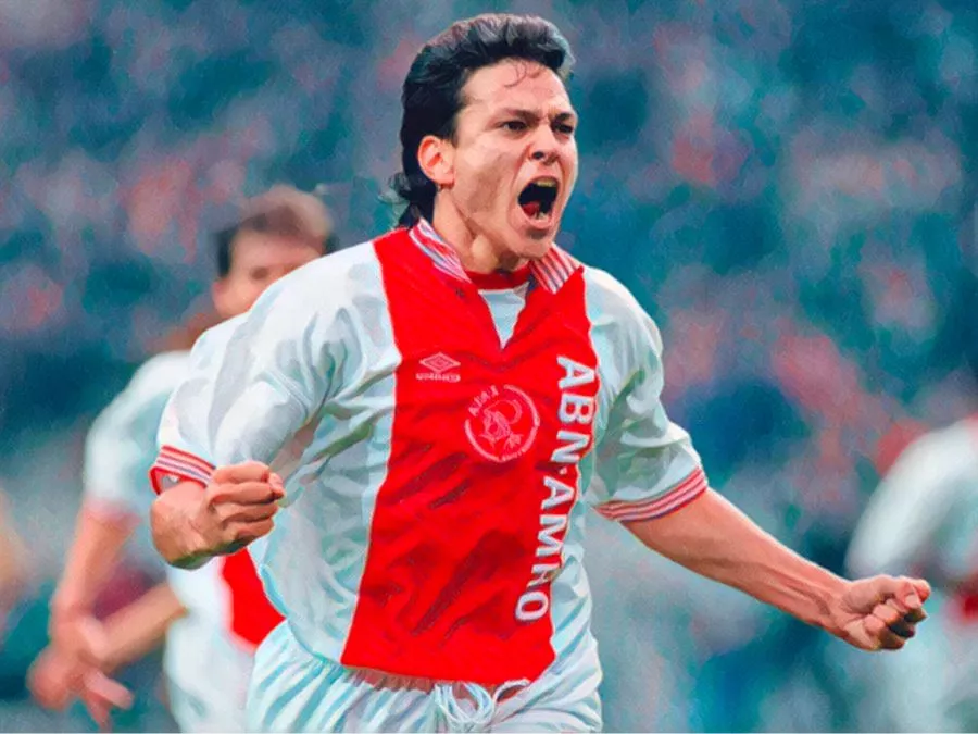Jari Litmanen esulta sorridendo con la maglia classica dell'Ajax