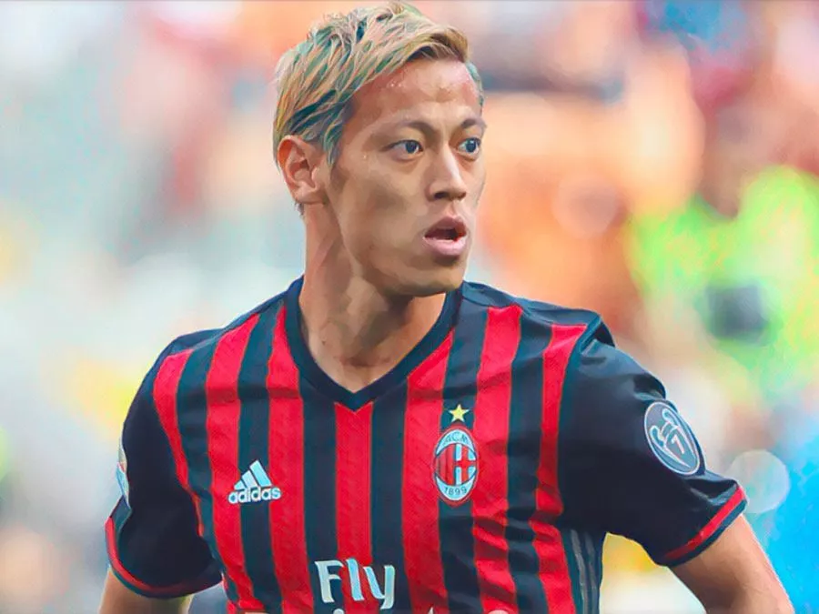 Keisuke Honda esulta con la maglia del Milan indicando il cielo dopo una rete su calcio di punizione