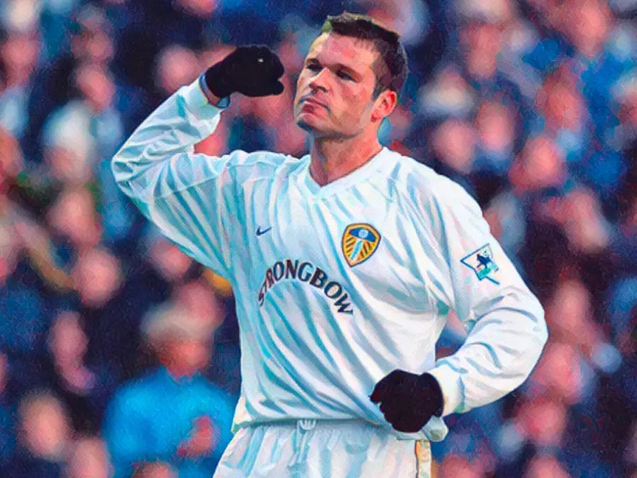 Mark Viduka esulta a braccia aperte con la maglia bianca del Leeds United dopo un gol in Premier League