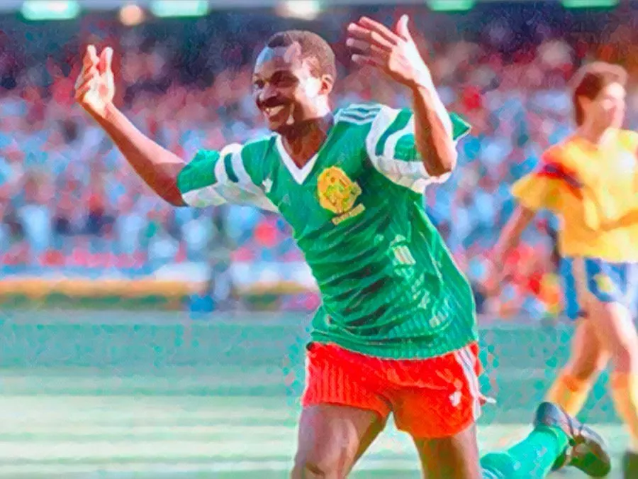 Roger Milla esulta ballando la Makossa vicino alla bandierina del calcio d'angolo con la maglia del Camerun durante Italia '90