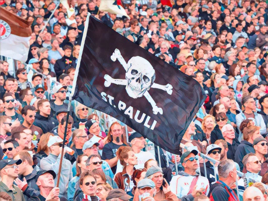 I tifosi del St. Pauli popolano la curva del Millerntor-Stadion sventolando la bandiera del teschio Jolly Roger