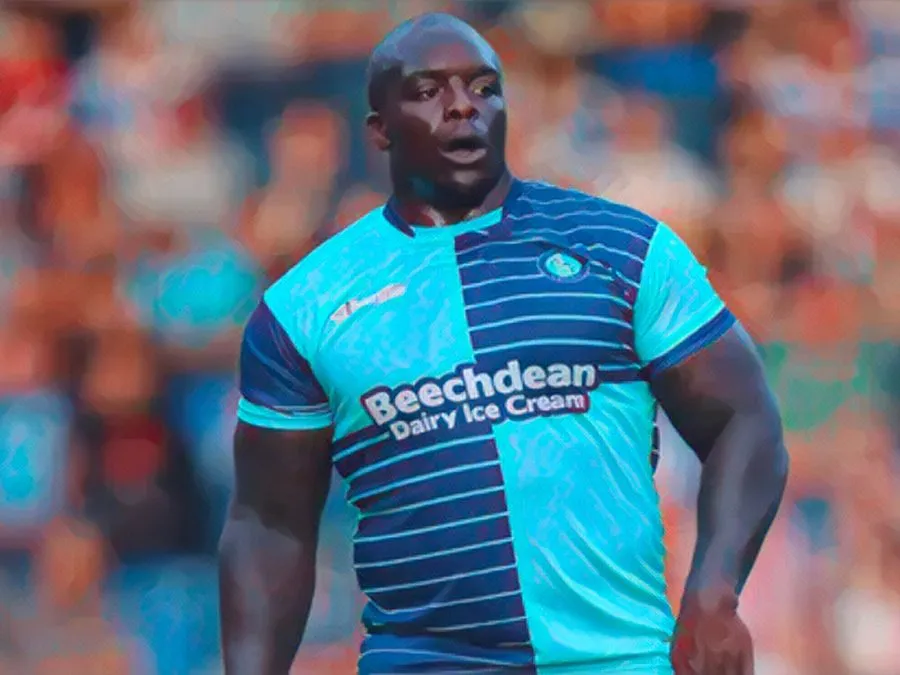 Adebayo Akinfenwa esulta mostrando i muscoli con la maglia dell'AFC Wimbledon