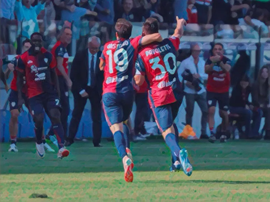 Leonardo Pavoletti esulta sommerso dai compagni di squadra dopo il gol del 4-3 contro il Frosinone alla Unipol Domus nel 2023