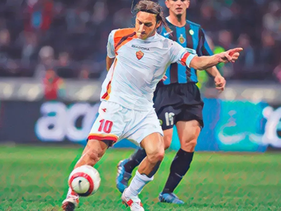 Francesco Totti esulta a braccia aperte sul prato di San Siro dopo il gol del cucchiaio contro l'Inter nel 2005