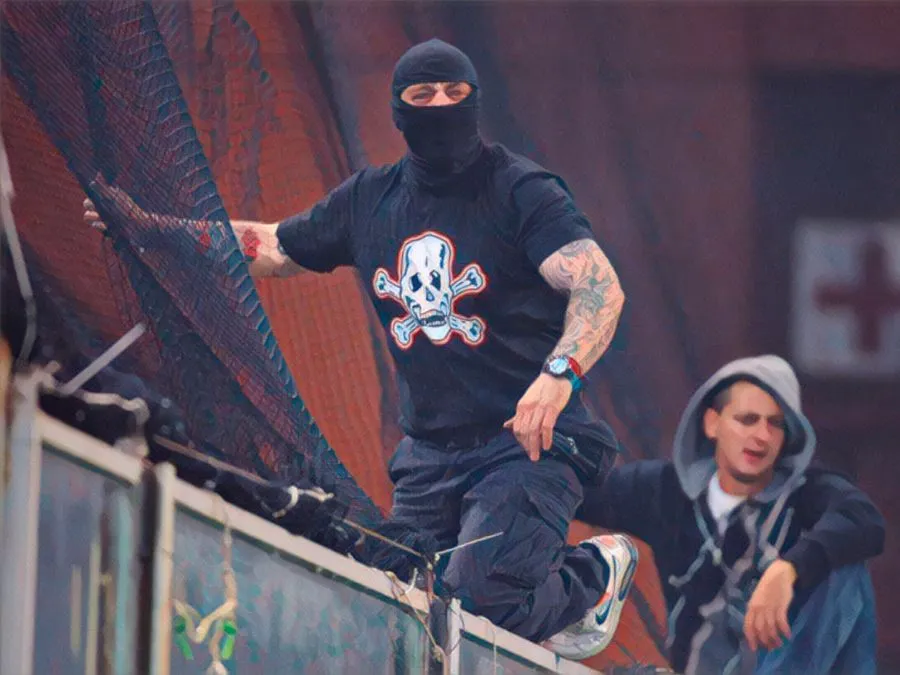Ivan Bogdanov a cavalcioni sulla rete di protezione del settore ospiti dello stadio Ferraris di Genova